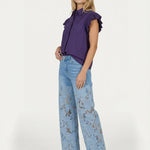 Model in paarse blouse en lichtblauwe jeans met kant, full-body shot | Jo&Co Club