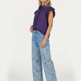 Model in paarse blouse en lichtblauwe jeans met kant, full-body shot | Jo&Co Club