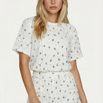 Witte T-shirt met zwart geborduurd patroon en textuur, gedragen door een model | Jo&Co Club