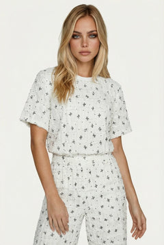 Witte T-shirt met zwart geborduurd patroon en textuur, gedragen door een model | Jo&Co Club