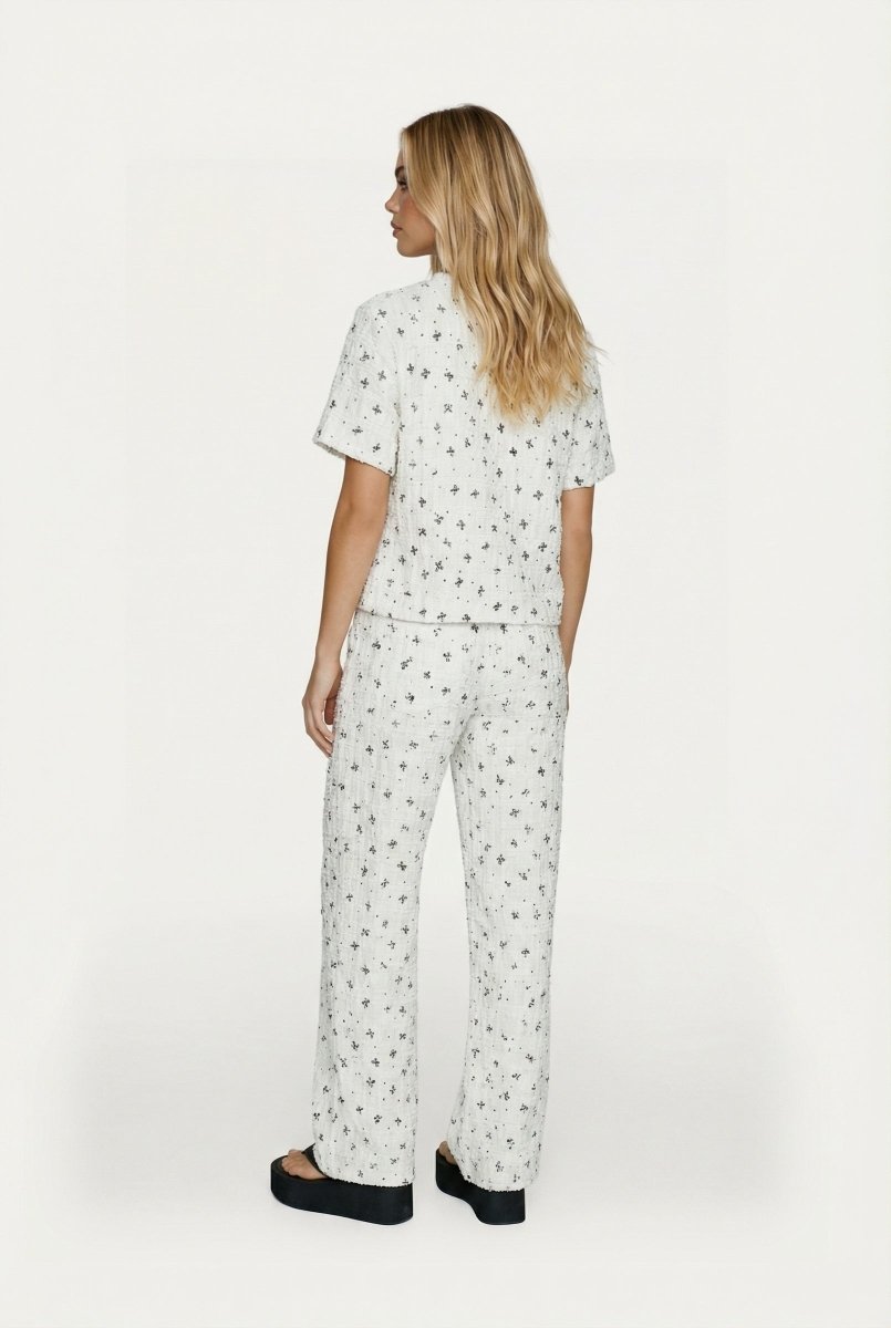 Witte tweedelige set met print – Achteraanzicht van top met korte mouwen en wijde broek | Jo&Co Club