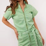 Vrouw draagt mintgroene Fluresk Idaly playsuit met rits en ceintuur, vooraanzicht.