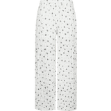 Broek pants Offwhite/Black – Witte broek met wijde pijpen en print van zwarte strikjes | Jo&Co Club