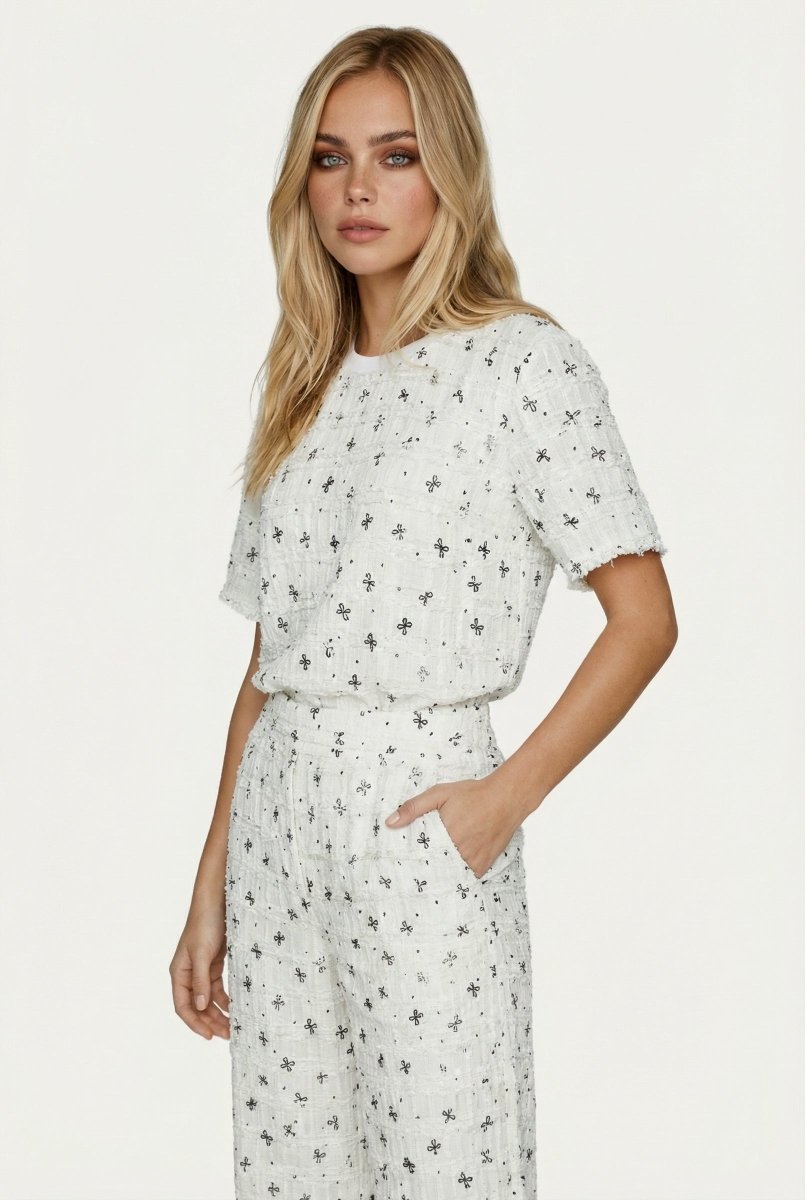 Tweed set wit – crèmewitte co-ord set met korte mouwen en een zwart strikjespatroon. | Jo&Co Club