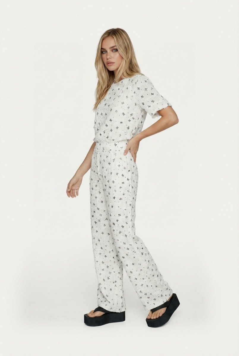 Tweedelige set wit – Set met tweed-look, korte mouwen, wijde pijpen en zwart patroon | Jo&Co Club