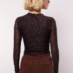 model draagt de lawrence top van fluresk in mocha bruin en zwart.