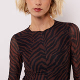model draagt de lawrence top van fluresk in mocha bruin en zwart.