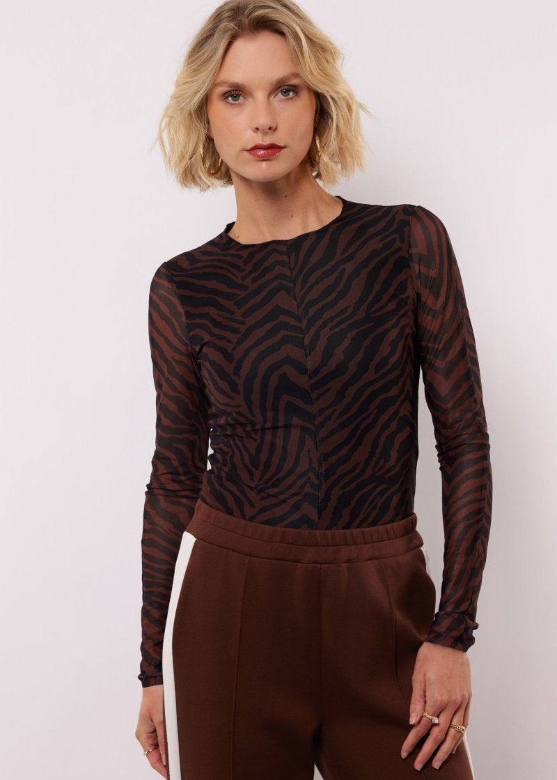 model draagt de lawrence top van fluresk in mocha bruin en zwart.