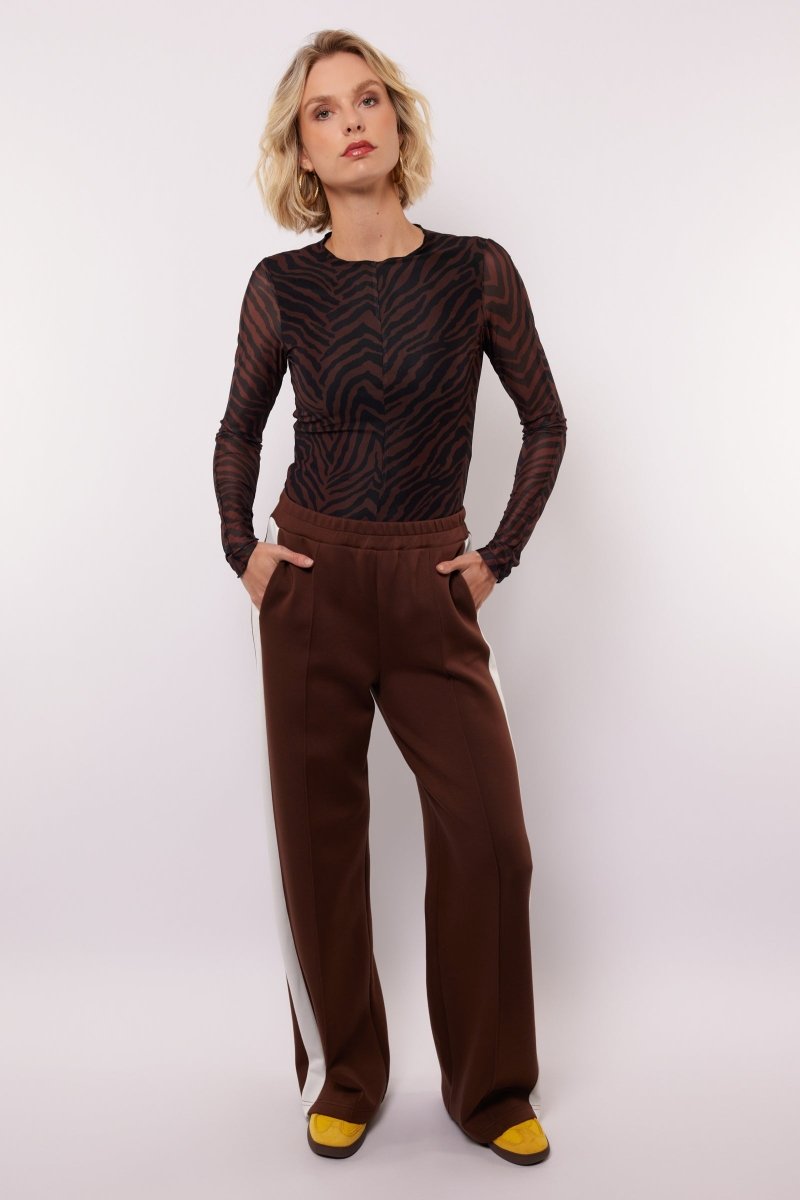 model draagt de mairen pants en de lawrence top van fluresk in het bruin 