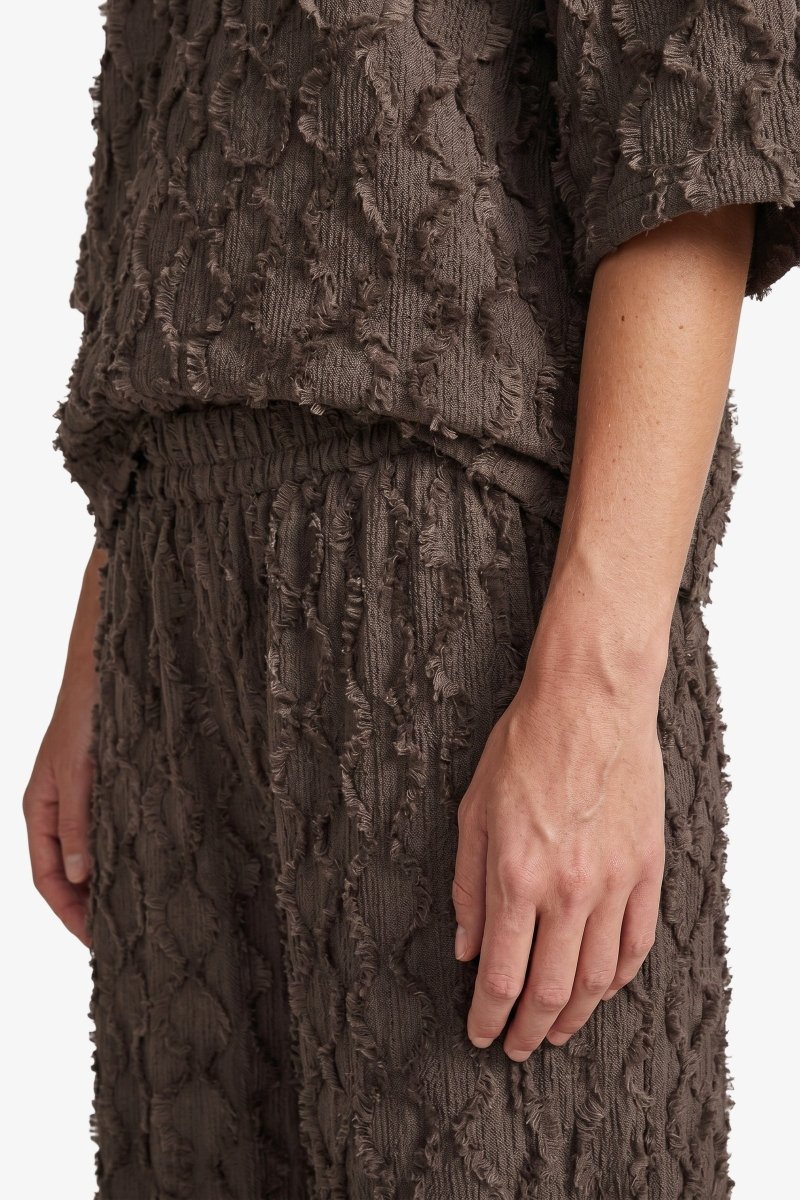 Bruine wijde broek met reliefstructuur, detailfoto | Fluresk Loa pants | Jo&Co Club
