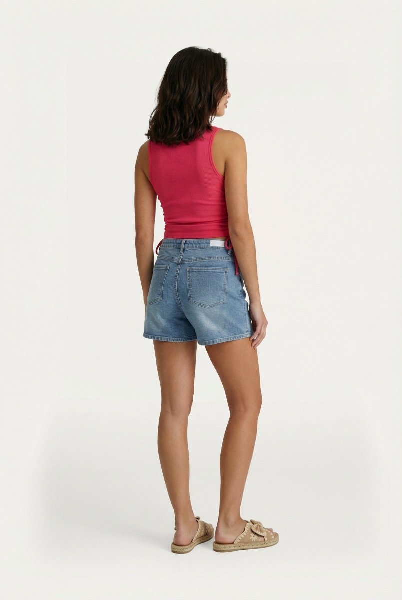 Een model, van achteren gefotografeerd, draagt een felroze, geribbelde tanktop en een lichtblauwe | Fluresk top | Jo&Co Club