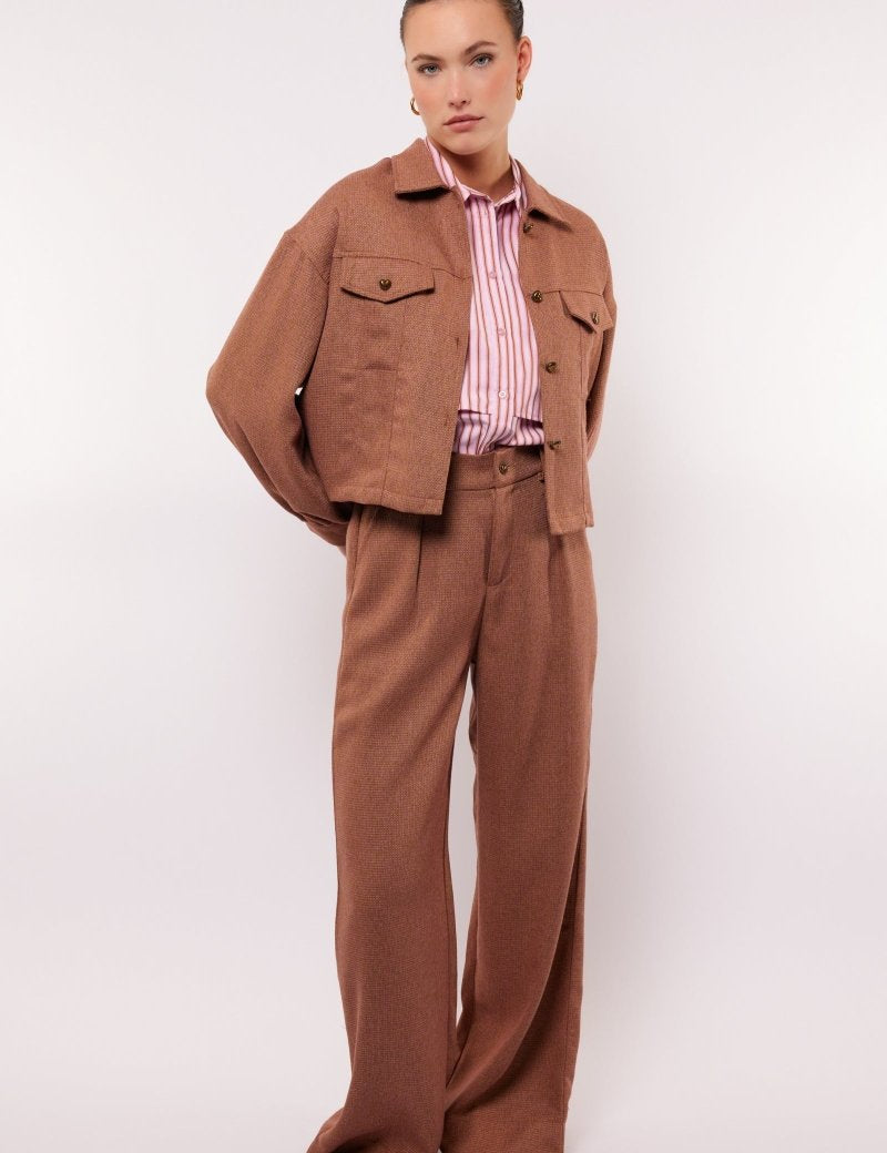 model draagt de fluresk ronja pants in het bruin met hartjes detail.