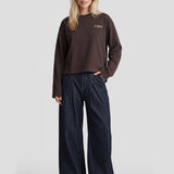 Model in bruine sweater Fluresk Anya met donkere wijde jeans, voorkant | Jo&Co Club