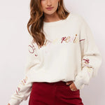 Model styled de Fluresk Veraline Sweater met een bordeauxrode wide leg broek.