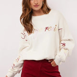 Model styled de Fluresk Veraline Sweater met een bordeauxrode wide leg broek.