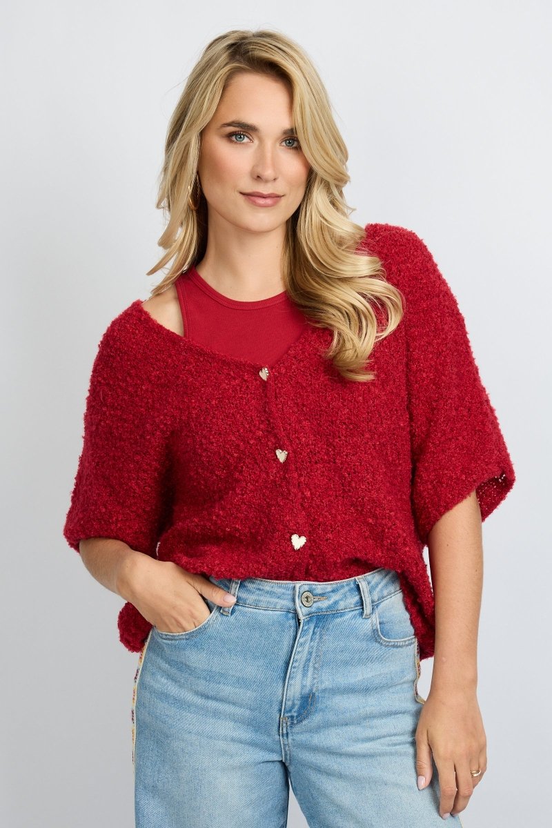 model draagt het fluresk yela vest in een rode kleur met hartjes knopen en een v-hals.