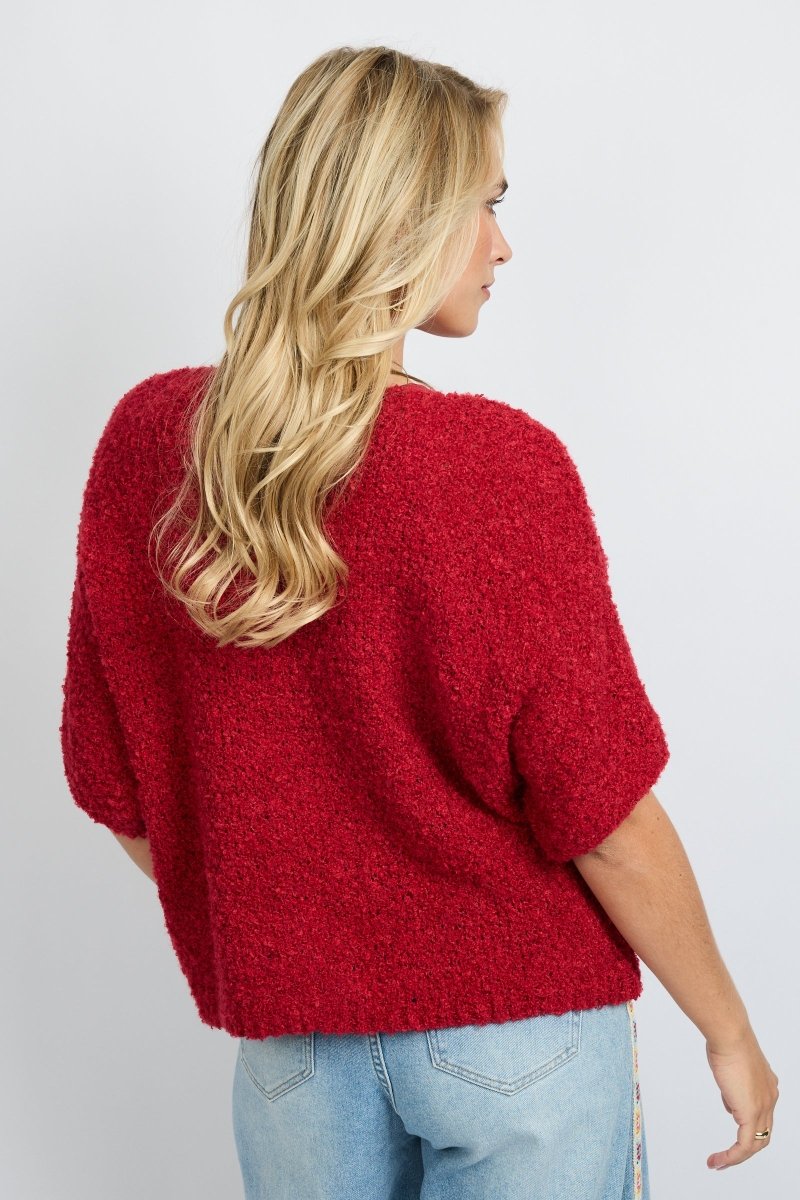 model draagt het fluresk yela vest in een rode kleur met hartjes knopen en een v-hals.