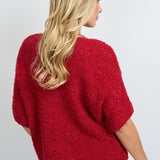 model draagt het fluresk yela vest in een rode kleur met hartjes knopen en een v-hals.