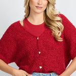 model draagt het fluresk yela vest in een rode kleur met hartjes knopen en een v-hals.