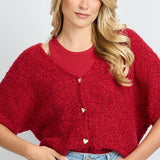 model draagt het fluresk yela vest in een rode kleur met hartjes knopen en een v-hals.