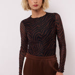 model draagt de lawrence top van fluresk in mocha bruin en zwart.