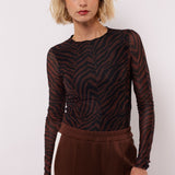 model draagt de lawrence top van fluresk in mocha bruin en zwart.