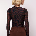 model draagt de lawrence top van fluresk in mocha bruin en zwart.