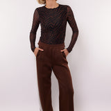 model draagt de mairen pants en de lawrence top van fluresk in het bruin 