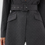 model draagt de Ann Blazer en de Ann trousers van heyb club in grijs met glitters en ceintuur.