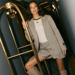 Campagnebeeld HEYB Club FW26: HC longsleeve grey/green van HEYB Club onder een geruite blazer | Jo&Co Club