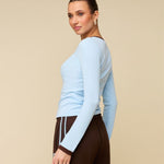Model in lichtblauwe longsleeve met bruine randjes HEYB Club, andere kant | Jo&Co Club