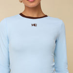 Model in lichtblauwe longsleeve met bruine randjes HEYB Club | Jo&Co Club