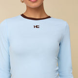 Model in lichtblauwe longsleeve met bruine randjes HEYB Club | Jo&Co Club