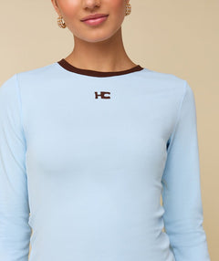 Model in lichtblauwe longsleeve met bruine randjes HEYB Club | Jo&Co Club