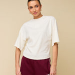 Model in crème boxy t-shirt met logo HEYB Club | Jo&Co Club