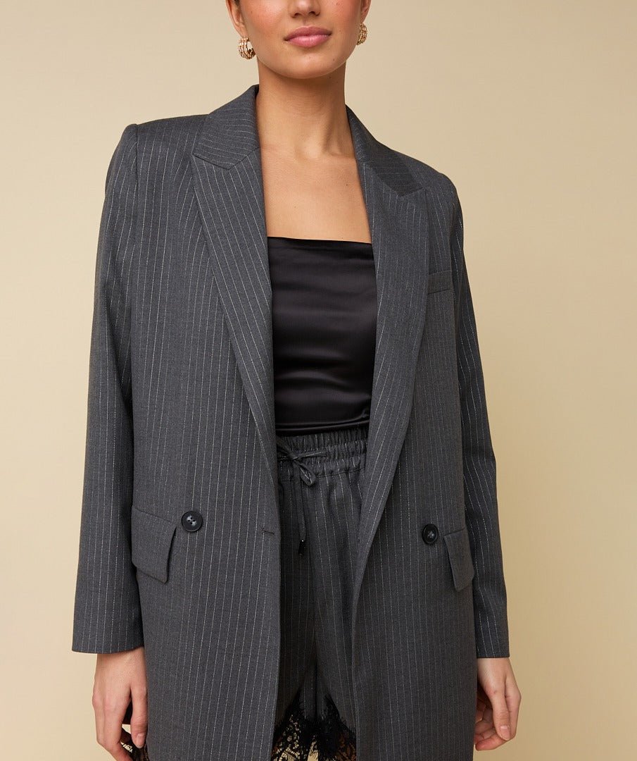 Model in grijze krijtstreep blazer HEYB Club Flo, andere kant | Jo&Co Club