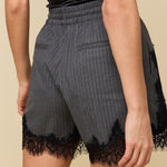 Model in grijze krijtstreep short met zwart kant HEYB Club Flo, andere kant | Jo&Co Club
