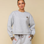 Model in grijze sweater met logo HEYB Club Celine, andere kant | Jo&Co Club