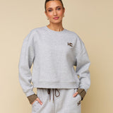 Model in grijze sweater met logo HEYB Club Celine, andere kant | Jo&Co Club