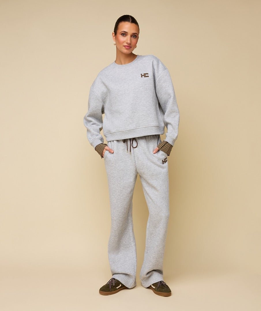 Model in grijze sweater met logo HEYB Club Celine | Jo&Co Club