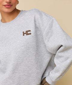 Model in grijze sweater met logo HEYB Club Celine, andere kant | Jo&Co Club