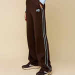 Model in bruine trainingsbroek met lichtblauwe bies HEYB Club Fallon | Jo&Co Club