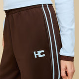 Model in bruine trainingsbroek met lichtblauwe bies HEYB Club Fallon, andere kant | Jo&Co Club