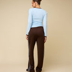 Model in bruine trainingsbroek met lichtblauwe bies HEYB Club Fallon, andere kant | Jo&Co Club
