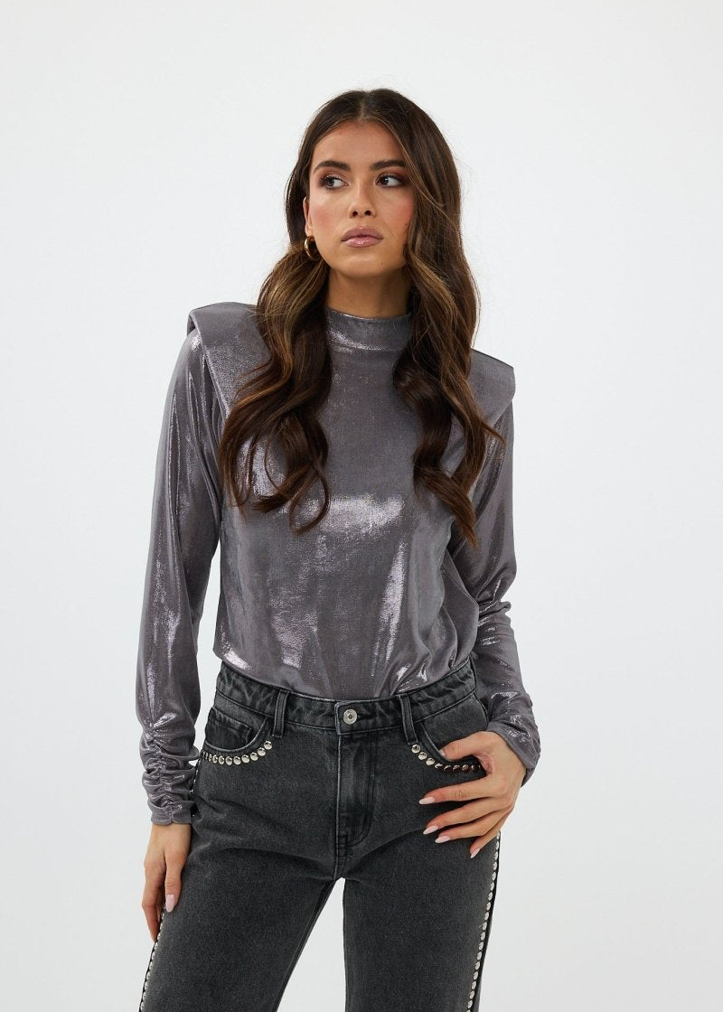 model draagt de nora top in zilver en de vegas jeans van heyb club.