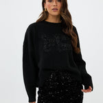 model draagt de riley rok van heyb club in zwart met pailetten en feax fur look.