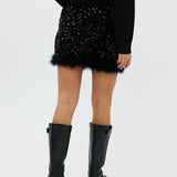 model draagt de riley rok van heyb club in zwart met pailetten en feax fur look.