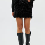 model draagt de riley rok van heyb club in zwart met pailetten en feax fur look.