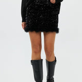 model draagt de riley rok van heyb club in zwart met pailetten en feax fur look.