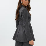 model draagt de Ann Blazer en de Ann trousers van heyb club in grijs met glitters en ceintuur.